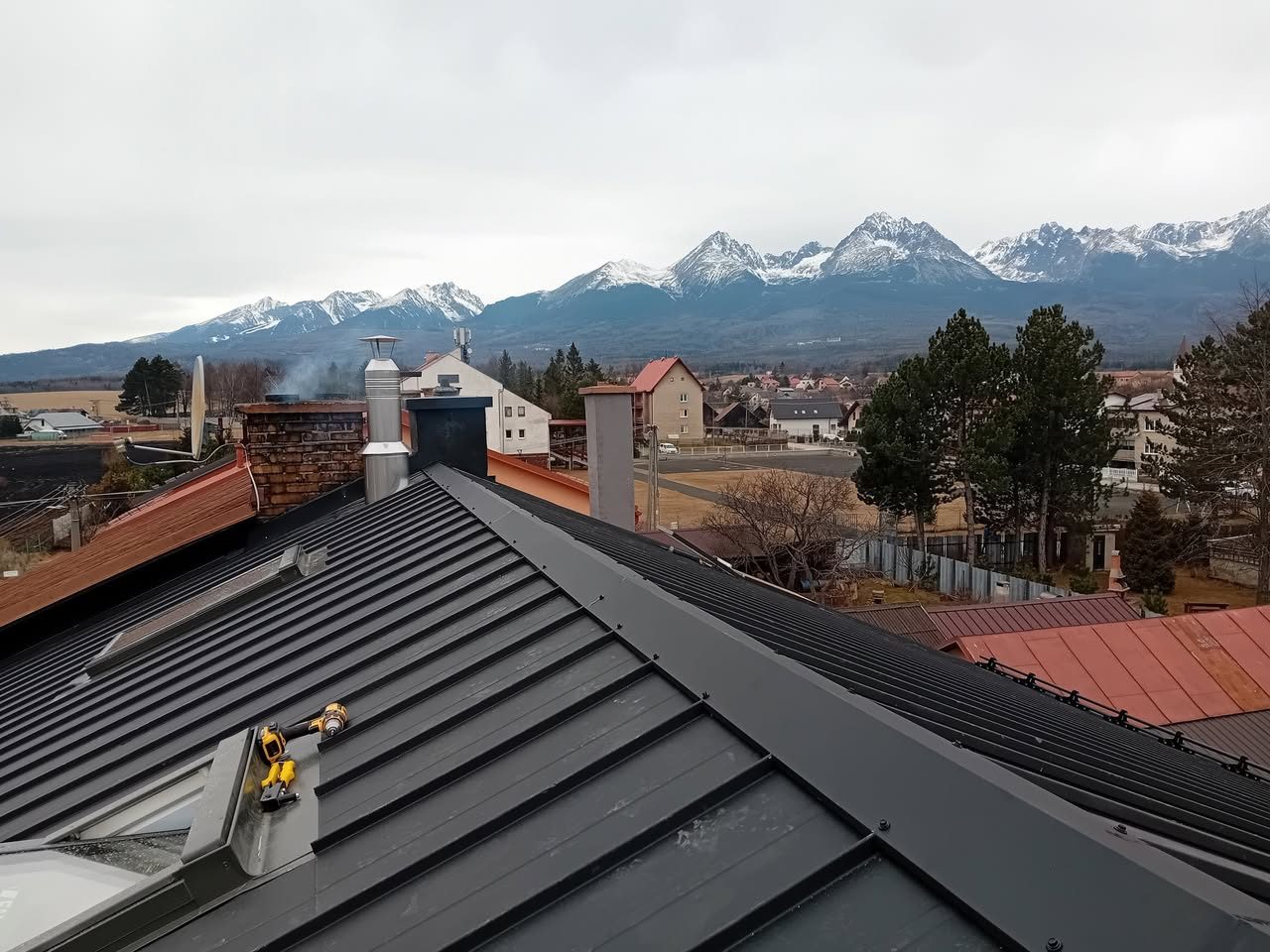 Falcovaná plechová strecha, ktorú realizovala firma Strechy Kolumber, v pozadí zasnežené Vysoké Tatry